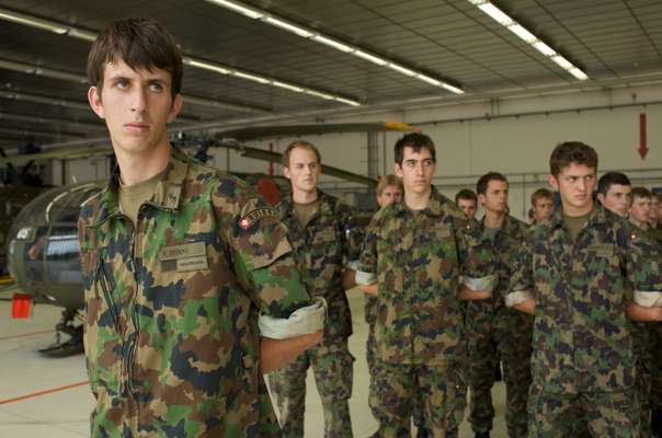 Swiss conscripts receiving instructions in a military hangar at Payerne