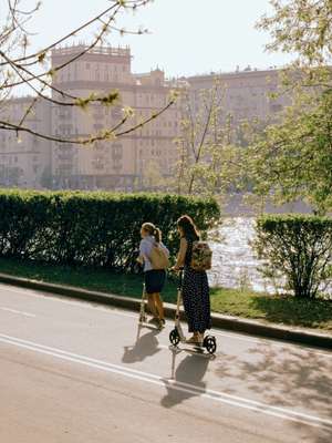 Scooter riders crossing a river embankment 