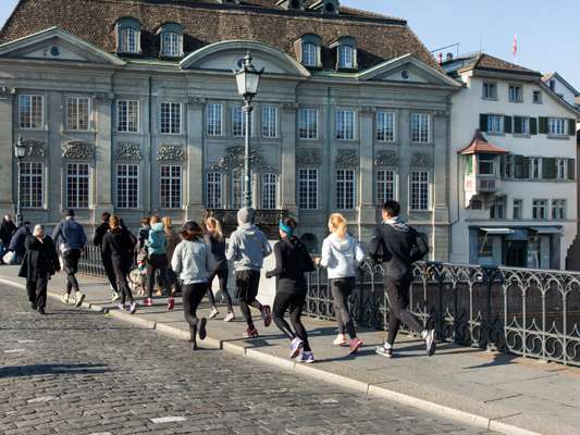 Running club crossing the Münsterbrücke in Zürich  