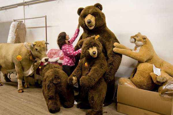 Steiff employee with a menagerie of life-size stuffed animals 