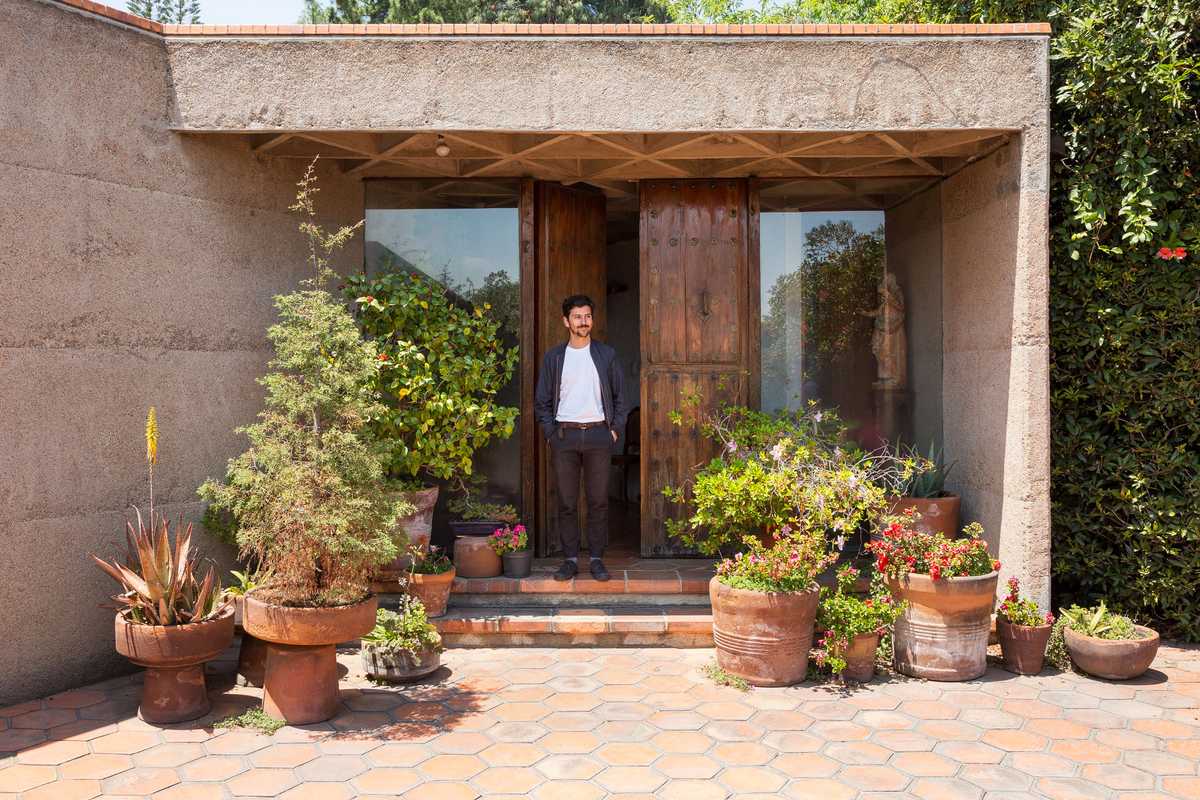 Carlos H Matos at the home’s plant-laden entrance