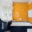 Orange ceramic glass tiles in the bathroom have a 1960s feel