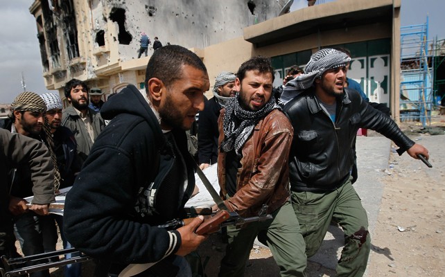 Libyan rebel fighters carrying a wounded comrade in Misurata 