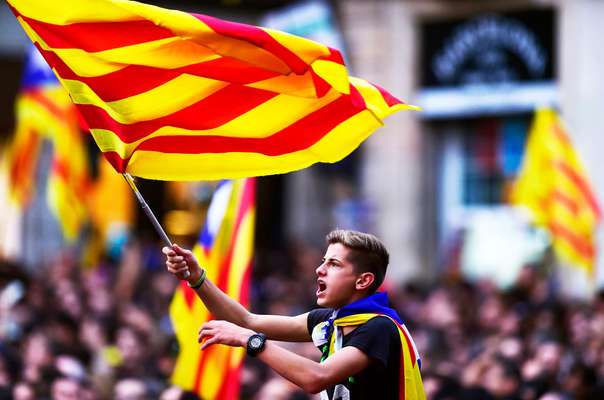 A boy waves a flag as people celebrate Catalonia's parliamentary vote to declare independence 