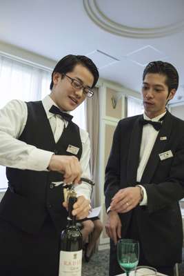 Instructor Shinji Ueno (right) showing a student how to use a cockscrew