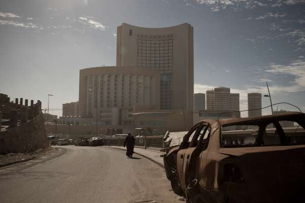 Burnt-out car in the shadow of the Corinthia Hotel