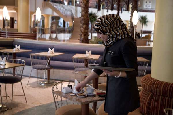 Malika serving coffee and cookies in the lobby café