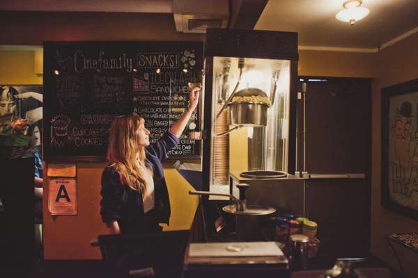 Cinefamily employee loading the popcorn machine