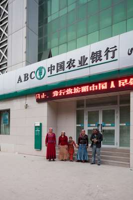 Uyghur family by a bank in downtown Kashgar