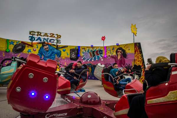 Young couples enjoying a ride at a newly reopened theme park, East Mosul