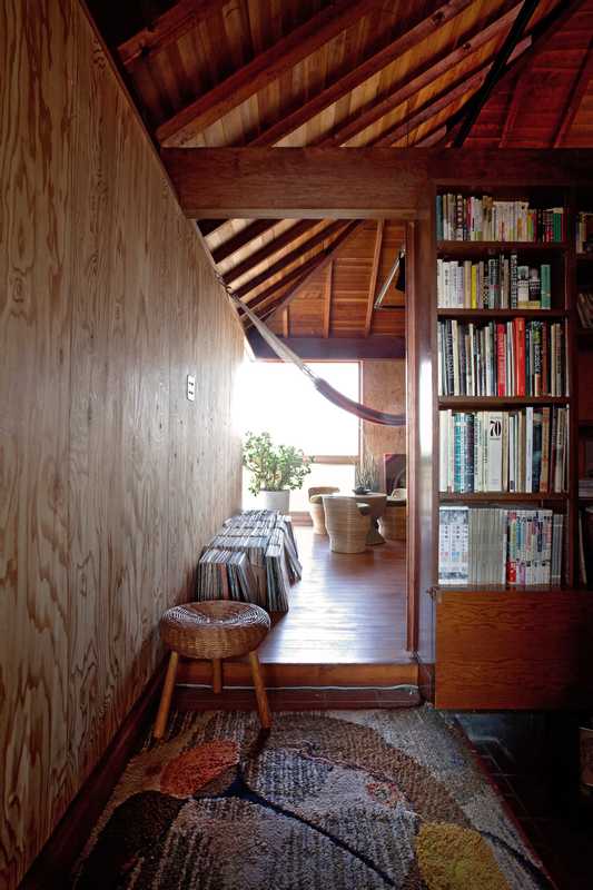 Second floor: Second floor, at the top of the stairs is a 1950s rug and rattan school. A bookshelf doubles as a partition. 