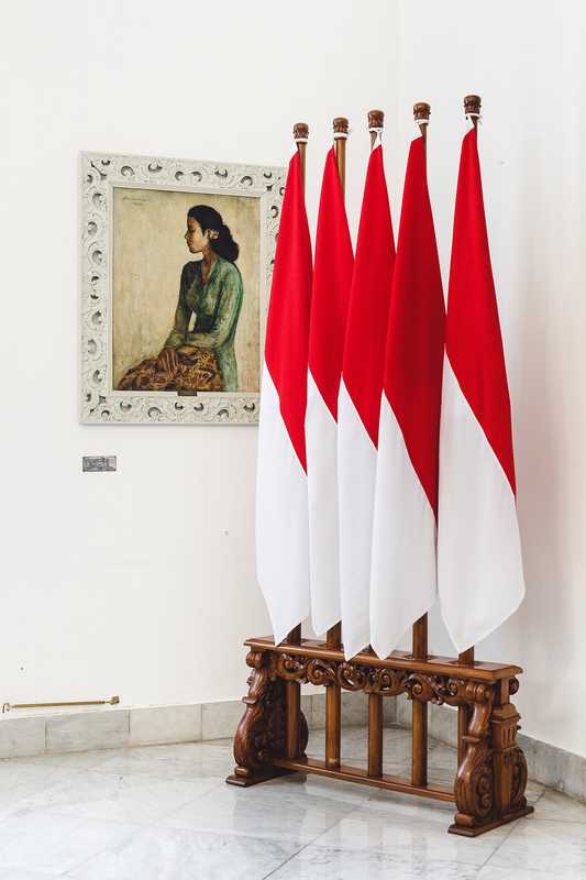 Sang Saka Merah-Putih (lofty red-and-white) flags with one of the palace’s many paintings 