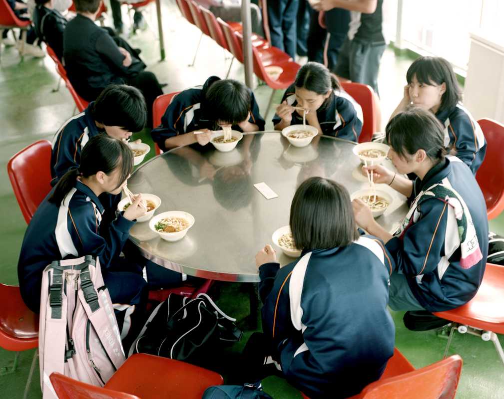 Students eat udon noodles on the ferry to Sakurajima