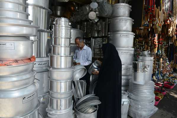 A woman in a black ‘chador’ in a shop selling aluminium goods