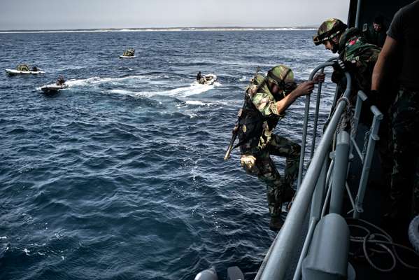 Marines scramble down ladders from the ‘Bérrio’ to small inflatable craft as they take part in a beach-landing exercise