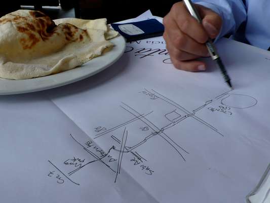 The former mayor sketches a map of Bogotá’s bike routes on a paper table setting 