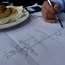 The former mayor sketches a map of Bogotá’s bike routes on a paper table setting 