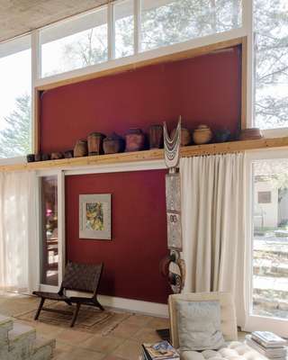 Living room with African sculpture; large windows allow for ample light 