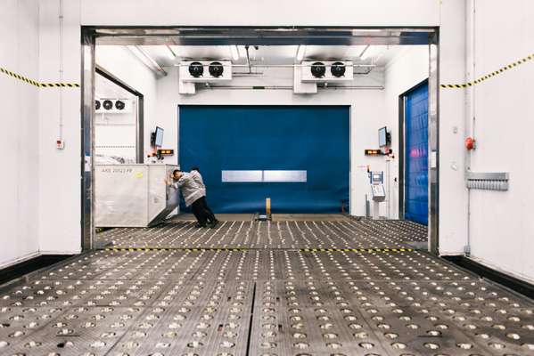 Staff moving temperature-sensitive cargo into a cold room