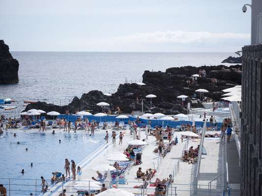 The rock escarpment connects the lido to the island’s volcanic landscape