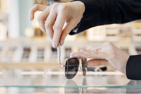 Optometrist making adjustments to a pair of sunglasses