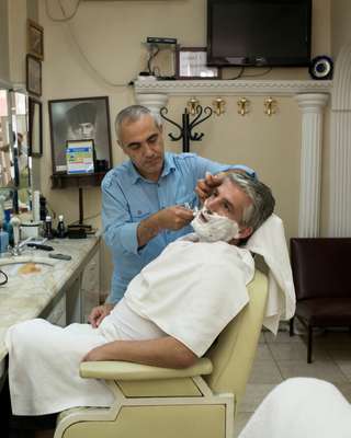 Akbay shaving a customer