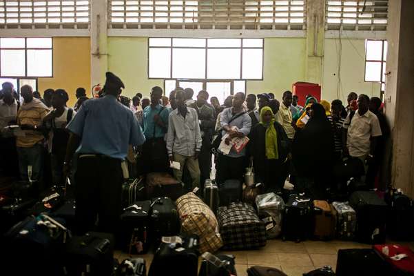 Recently arrived passengers wait to collect their luggage