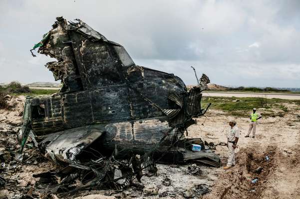 Sean Mendis, SKA station manager, next to the wreckage of an Ethiopian Air Force flight that crash-landed on 9 August 2013. The plane was carrying some 15 tonnes of ammunition destined for international forces in Somalia 
