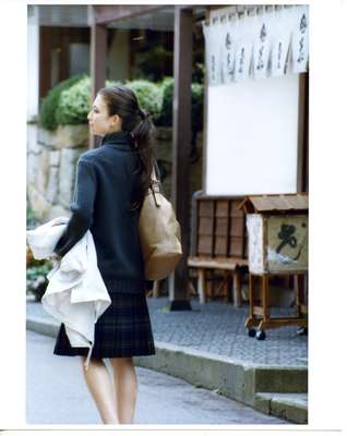 Jumper by Drawer, skirt by Prada, coat (carried) by Knott from Tomorrowland, bag by Jimmy Choo