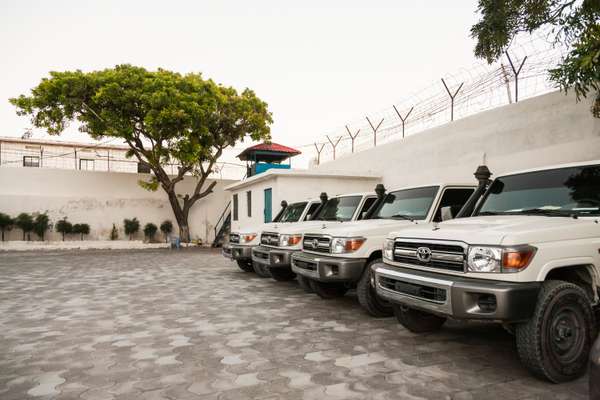 Toyota Land Cruisers line the inside of the compound