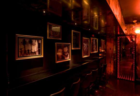 Sparkling mirrors and black-and-white photos line the black walls of the club’s long corridor
