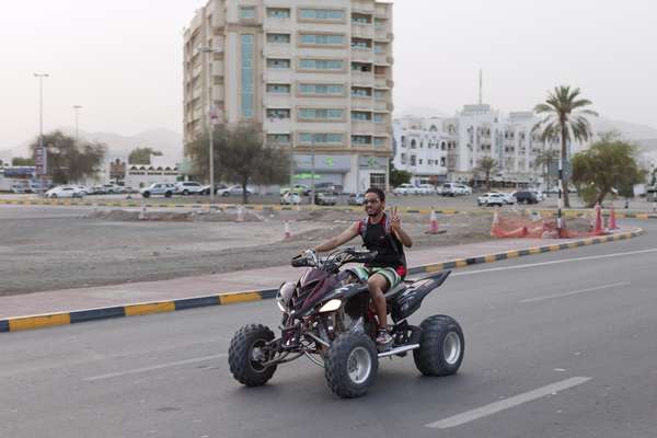 A man drives down the corniche on an all terrain vehicle