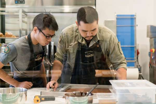 Chefs preparing chocolate tuile (baked wafers) in  the kitchen