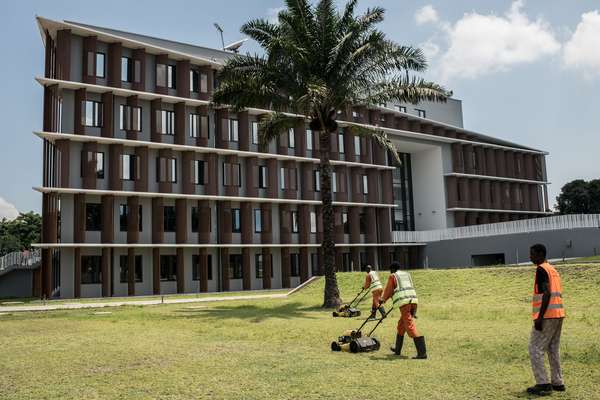 Congolese workers mowing the lawn at the new Belgian embassy in Kinshasa