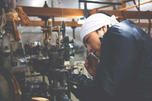 Ryohei Kawasaki carefully removes dust from spinning gears