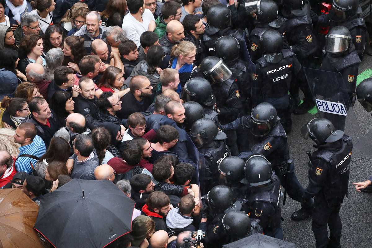 Police face off with demonstrators outside a polling station, in Barcelona, Spain, 1 October 2017
