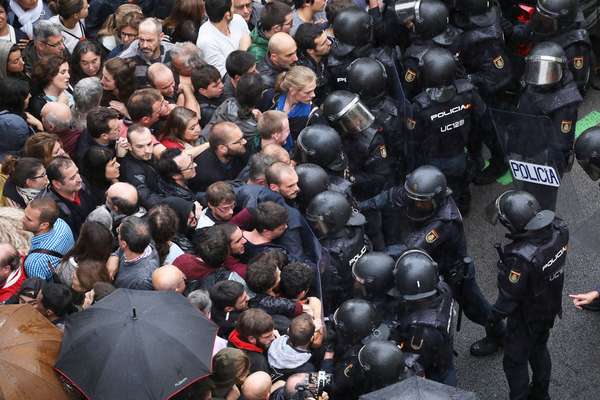 Police face off with demonstrators outside a polling station, in Barcelona, Spain, 1 October 2017