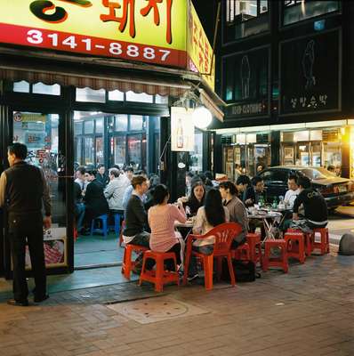 Roadside food seller in Hongdae, cooking on a traditional barbecue