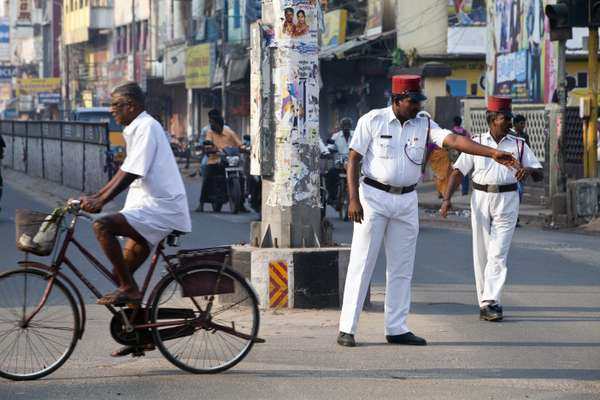 A Pondicherry policeman directs traffic wearing a French-style uniform, complete with kepi