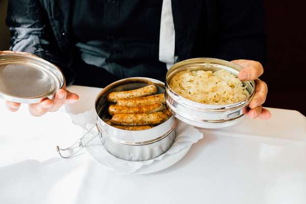 Takeaway lunchbox – presented to Wenders during the meal – of sausages with sauerkraut and mustard