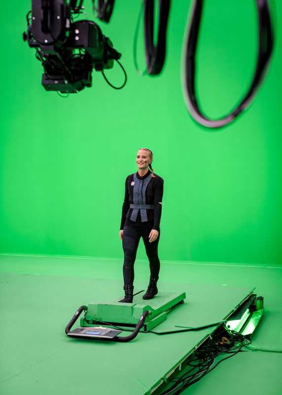 Walking on a green treadmill, which simulates walking in a virtual environment