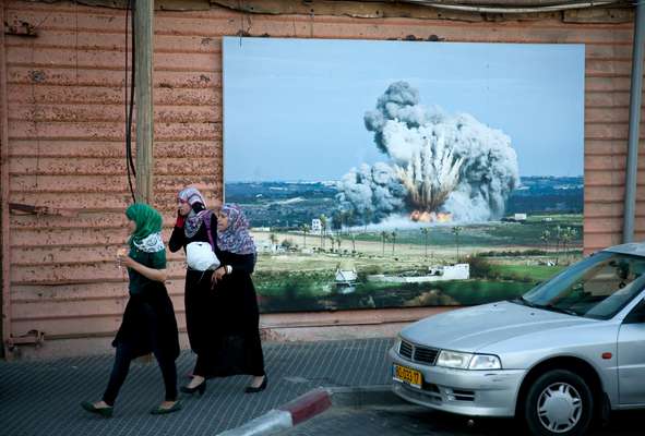 Conservative Palestinian Women in Jaffa’s old port walk in front of a public photo exhibition