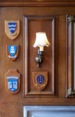 Ships’ badges on a  wall of the reading room