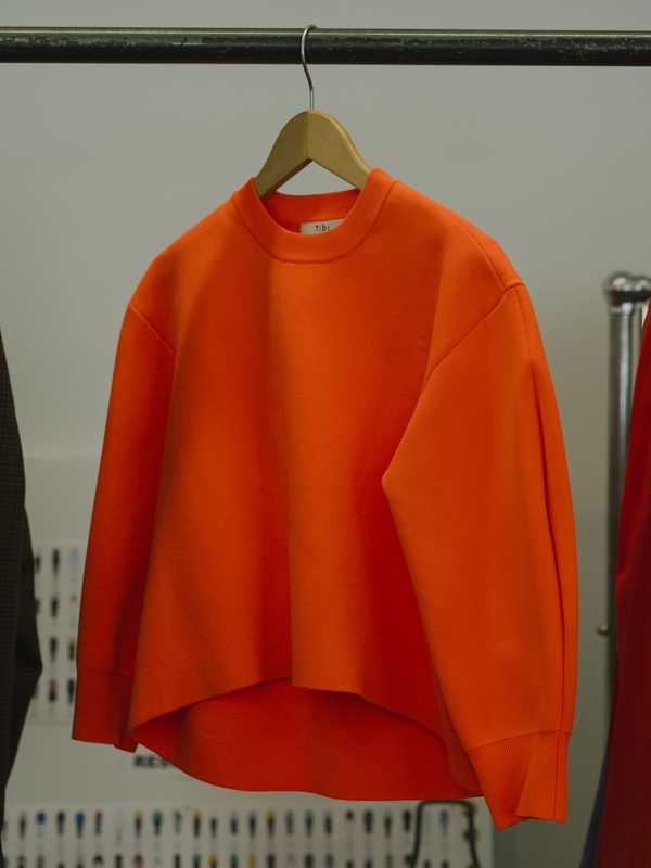 Orange sweater hanging in-store