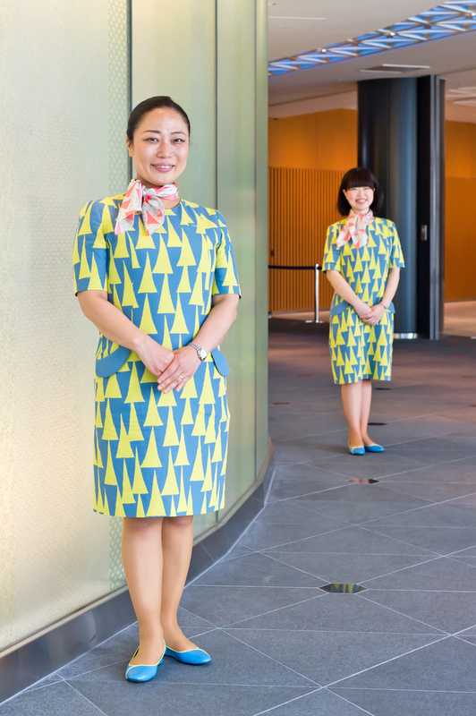 Guides wear dresses designed by Akira Minagawa, featuring the tower motif