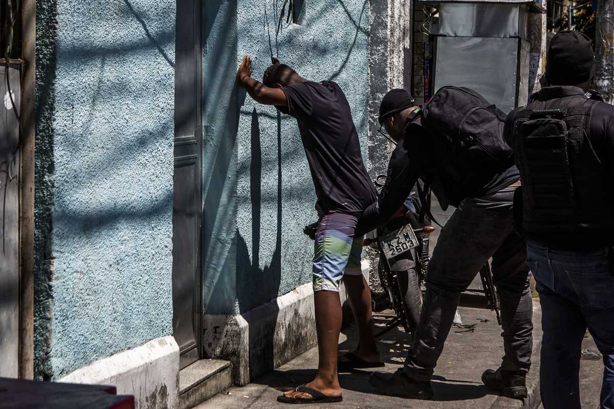 Military police frisking a man during a routine operation to combat drug-trafficking in the Cruzeiro favela.