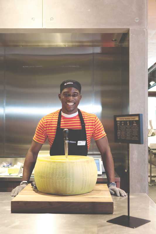 An employee about to crack into a wheel of Parmesan
