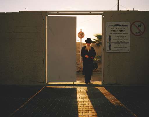 An Orthodox Jew leaves a men-only beach in Tel Aviv